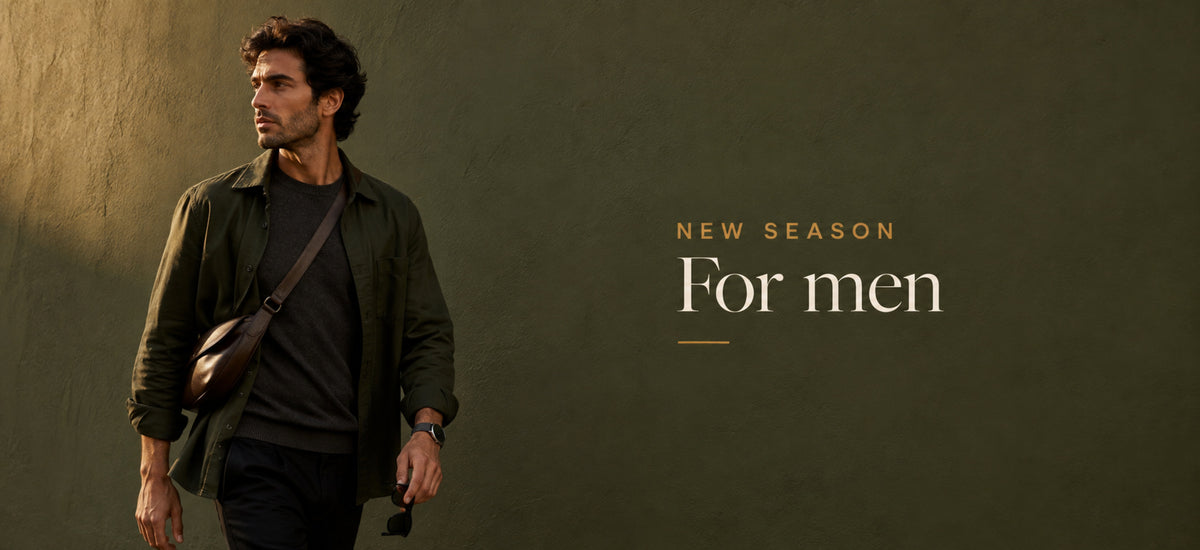 Men's desktop banner with man wearing an olive overshirt and dark leather crossbody bag